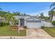 Charming single-story home featuring a well-maintained lawn, mature palm trees, and a two-car garage at 11619 Fox Creek Dr, Tampa, FL 33635
