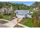 High-angle shot of a single-story home featuring a well-maintained lawn, mature palm trees, and a two-car garage at 11619 Fox Creek Dr, Tampa, FL 33635