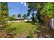 Sprawling backyard offering ample space for recreation, bordered by mature trees and a white fence at 119 N Hillcrest Ave, Clearwater, FL 33755