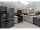 Updated kitchen featuring stainless steel appliances, gray cabinets, and subway tile backsplash at 119 N Hillcrest Ave, Clearwater, FL 33755