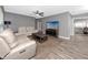 A cozy living room with a ceiling fan, leather sofas, a TV, and wood-look vinyl floors at 119 N Hillcrest Ave, Clearwater, FL 33755