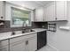 Kitchen sink with stainless steel hardware, subway tile backsplash, and gray cabinets at 119 N Hillcrest Ave, Clearwater, FL 33755