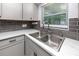 Stainless steel kitchen sink features new gooseneck faucet, and stone countertops at 119 N Hillcrest Ave, Clearwater, FL 33755