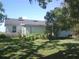 Backyard of the home showcasing lush greenery, and ample space for outdoor activities at 11951 Wichers Ln, San Antonio, FL 33576