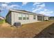 Exterior of home, with an AC unit, covered patio, and bare lawn under a cloudy sky at 12436 Shining Willow St, Riverview, FL 33579