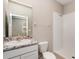 Bathroom featuring a single granite vanity with a sink, a white tiled shower, and a toilet at 12436 Shining Willow St, Riverview, FL 33579