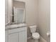 Neutral powder room featuring a granite countertop, white vanity, tile flooring and a standard toilet at 12436 Shining Willow St, Riverview, FL 33579