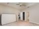 Bright bedroom with neutral paint and trim, carpet flooring, fan, and entry to kitchenette and bathroom at 12436 Shining Willow St, Riverview, FL 33579