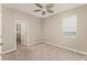Neutral bedroom with a ceiling fan, window, carpet and a door to another room at 12436 Shining Willow St, Riverview, FL 33579