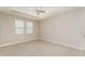 Large room with tile flooring, two windows, fan, and neutral walls and trim at 12436 Shining Willow St, Riverview, FL 33579