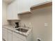 Kitchenette features granite countertops, white cabinets, stainless steel sink, and tile flooring at 12436 Shining Willow St, Riverview, FL 33579