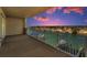 Spacious balcony with metal railing offering tranquil sunset views of waterfront and neighboring homes at 125 Island Way # 502, Clearwater Beach, FL 33767
