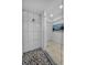 This bathroom features a tiled shower with a glass door and marble floors at 125 Island Way # 502, Clearwater Beach, FL 33767