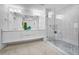 This bathroom features a double vanity, a modern glass shower, tile floors and a large mirror at 125 Island Way # 502, Clearwater Beach, FL 33767