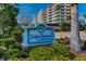 Dolphin Harbour Condominium sign surrounded by lush landscaping and building in the background at 125 Island Way # 502, Clearwater Beach, FL 33767