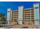 A condo building's exterior with a tropical-style landscape around the parking area at 125 Island Way # 502, Clearwater Beach, FL 33767