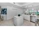 Bright kitchen with white cabinets, island, stainless steel appliances, and views from the windows at 125 Island Way # 502, Clearwater Beach, FL 33767