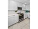 Bright kitchen features stainless steel oven, microwave, white cabinets, and elegant quartz countertops at 125 Island Way # 502, Clearwater Beach, FL 33767