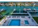 Overhead shot of community pool featuring lounge chairs, surrounding neighborhood and tranquil waterfront docks at 125 Island Way # 502, Clearwater Beach, FL 33767