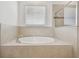 Luxurious soaking tub surrounded by tile, perfect for relaxation, plus a view of the tiled shower at 12710 Wheatgrass Ct, Parrish, FL 34219