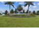 Beautifully landscaped community entrance sign with manicured lawns and palm trees at 12710 Wheatgrass Ct, Parrish, FL 34219