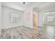 Bright, empty room with wood-look tile flooring, white walls, and modern lighting at 12710 Wheatgrass Ct, Parrish, FL 34219