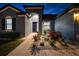Covered front porch entrance with landscape, rock features, and a pop of color from garden foliage at 12710 Wheatgrass Ct, Parrish, FL 34219
