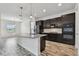 Contemporary kitchen with island, pendant lighting, and stainless appliances, open to the living space at 12710 Wheatgrass Ct, Parrish, FL 34219