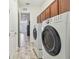 Convenient laundry room with washer, dryer, wood-look tile floor and ample cabinet space at 12710 Wheatgrass Ct, Parrish, FL 34219