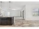 Bright living room with tile floors, a sliding glass door, and modern lighting at 12710 Wheatgrass Ct, Parrish, FL 34219