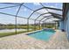Relaxing pool area with screened enclosure, brick pavers, and serene lake views creating a tranquil oasis at 12710 Wheatgrass Ct, Parrish, FL 34219