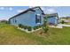 Landscaped side yard with decorative rock and a view of the blue home's exterior at 12710 Wheatgrass Ct, Parrish, FL 34219