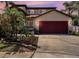 Charming two-story home features a two-car garage and a well-manicured front yard with tropical landscaping at 1313 Key West Ct, Wesley Chapel, FL 33544