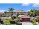 Charming two-story home with manicured landscaping, a red garage door and a well kept lawn at 1313 Key West Ct, Wesley Chapel, FL 33544