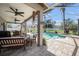 Relaxing screened-in patio with ceiling fans, seating, and a clear view of the beautiful pool at 1313 Key West Ct, Wesley Chapel, FL 33544