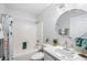 Cozy bathroom featuring shower-tub combo, neutral walls, and a round mirror at 14128 Pomona Ave, Spring Hill, FL 34609