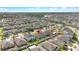 An aerial view showcases the homes in a vibrant neighborhood with lush greenery at 15507 Caynor Ash Ln, Sun City Center, FL 33573