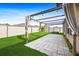 Backyard with wooden pergola over a concrete patio and lush green grass at 15507 Caynor Ash Ln, Sun City Center, FL 33573