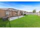 Backyard featuring a patio with a pergola, lush green grass, and a wooden fence at 15507 Caynor Ash Ln, Sun City Center, FL 33573
