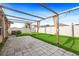 Backyard with a large pergola over a patio with grassy area and white fence at 15507 Caynor Ash Ln, Sun City Center, FL 33573