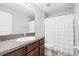 Clean bathroom with granite-topped vanity, white shower curtain, and efficient toilet at 15507 Caynor Ash Ln, Sun City Center, FL 33573