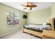 Cozy bedroom with green walls, natural wooden bedframe, and a ceiling fan with leafy design at 15507 Caynor Ash Ln, Sun City Center, FL 33573