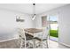 Bright dining area with backyard view, set for six, with modern light fixtures at 15507 Caynor Ash Ln, Sun City Center, FL 33573