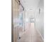 Bright hallway featuring a barn door, leading to a living space, and neutral tile flooring at 15507 Caynor Ash Ln, Sun City Center, FL 33573