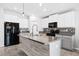 Bright, modern kitchen with white cabinets, stone countertops, stainless steel appliances, and central island at 15507 Caynor Ash Ln, Sun City Center, FL 33573