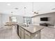 Open kitchen with granite counters, stainless steel appliances and a view of the dining and living areas at 15507 Caynor Ash Ln, Sun City Center, FL 33573