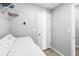 Laundry room with gray walls and tile flooring next to a standard white laundry machine at 15507 Caynor Ash Ln, Sun City Center, FL 33573