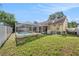 Spacious backyard featuring a screened pool, lush green grass, and a privacy fence at 16201 Country Crossing Dr, Tampa, FL 33624
