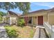Inviting home exterior featuring a red front door, well-kept landscaping, and a covered entryway at 16201 Country Crossing Dr, Tampa, FL 33624