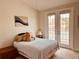 Sunlit bedroom with walkout to balcony with teddy bears on bed, neutral walls and trim and unique artwork at 184 Banyan Bay Dr, St Petersburg, FL 33705